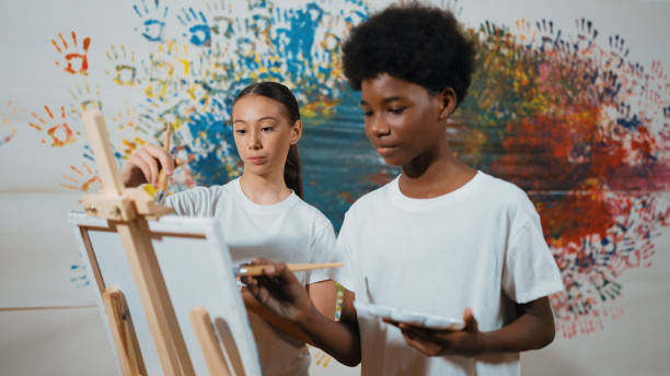 istock Diverse happy children paint canvas together with stained wall. Edification. 1941305535