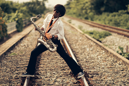Musician with saxophone  against a gray backdrop