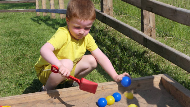 istock Red headed Child playing with toys in Sand Pit 1941334863