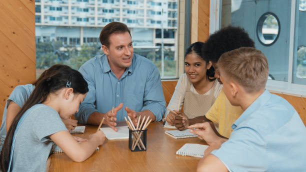 istock Caucasian teacher and smart boy discuss about project at class. Edification. 1941357681