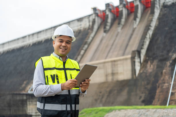 istock Professional asian maintenance engineer man with safety helmet in construction site dam with hydroelectric power plant and irrigation. Manager engineer man working with tablet at project big building. 1941414765