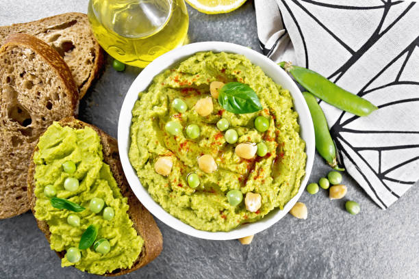 istock Hummus from green peas in bowl on stone table top 1941414770