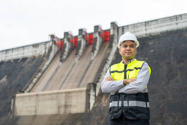 istock Professional asian maintenance engineer man with safety helmet in construction site dam with hydroelectric power plant and irrigation. Manager engineer man working at project big building. 1941415298