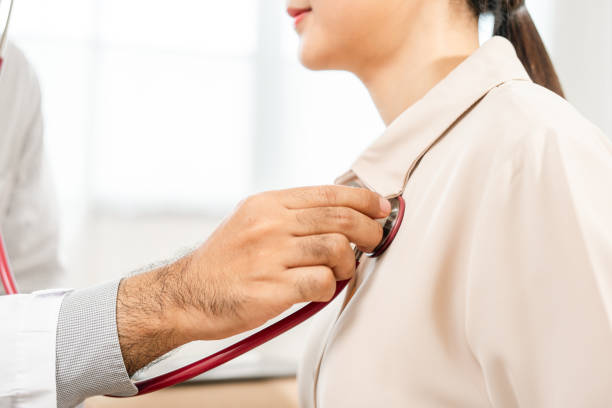 doctor using stethoscope to exam woman patient heart. female patient checking up heart rate and lungs in examination room at clinic hospital. medicine and health care treatment result - stethoscope paramedic working heart disease fotografías e imágenes de stock