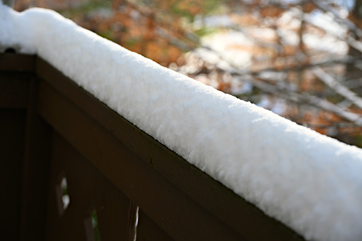 Freshly fallen snow from an overnight winter storm covers the top of a fence.