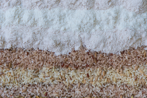 Organic Rice grains and homemade rice  flour the culinary ingredient on concrete background, Thai native rice varieties, healthy food concept, Top view.