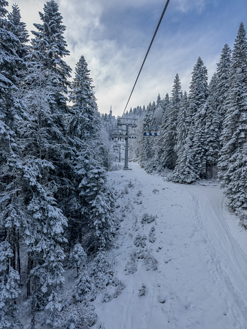 Open air ski lift and ski slope on overcast winter day