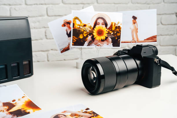 istock Printer and photo camera on table. Printing photos concept 1941512550