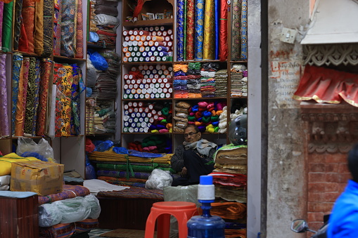Kathmandu, Nepal - November 26 2023: unidentified tailor feel tire in his tailor store in kathmandu