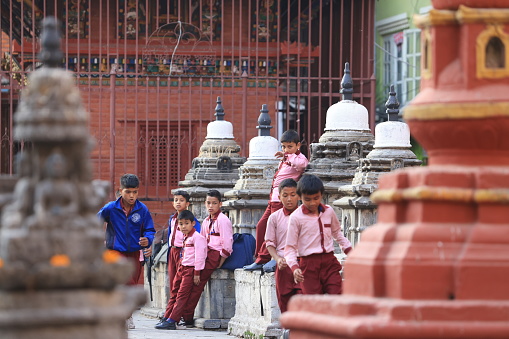 Young Burmese schoolboys with thanaka sitting under the tree, Nyaung-U, Myanmar (Burma)