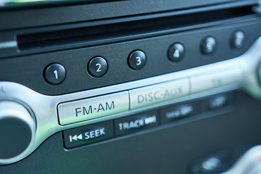 Closeup of a modern car radio control panel with buttons in a car