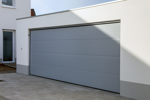 New grey garage door (sectional door) on the garage of a residential building