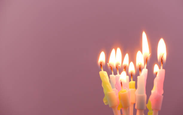 istock Birthday candles burning on pink background, copy space for text. 1941673600