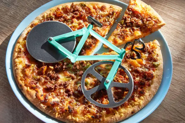 Kitchen pizza cutter like a bicycle on wooden table