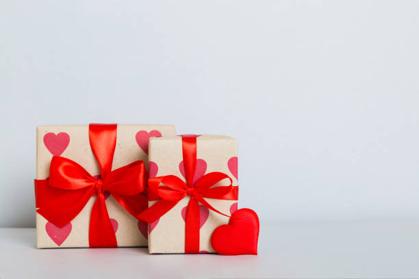 istock gift box with red bow and red heart on colored background. Perspective view. Flat lay 1941679986