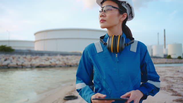 Asian Female Engineer working at industrial, oil or gas plant.