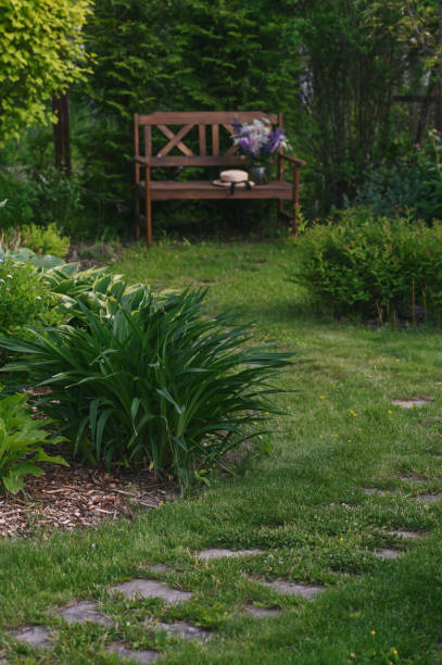 istock rustic summer cottage garden view with wooden bench. 1941744022