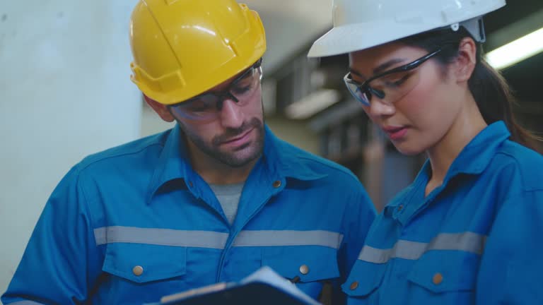 Engineers using a digital tablet together in an industrial place of work.