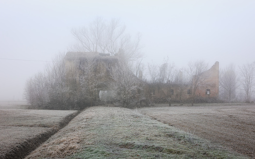 An abandoned country farmhouse ona a frosty and foggy morning
