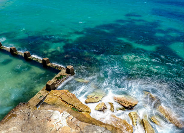 istock Powerful white swirling waves (blurred motion) crashing into rocky coastline 1941796566
