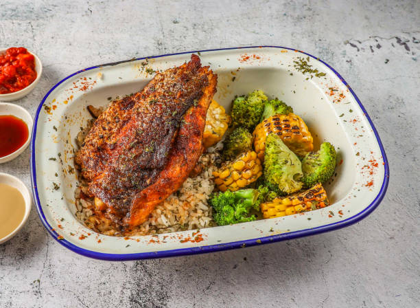 grilled sea bass or seabass fish with fried rice, grilled corn and broccoli served in isolated on grey background top view of singaporean food - sea bass prepared fish food grilled imagens e fotografias de stock