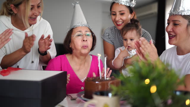 Family wishing happy birthday to senior woman