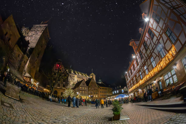 vista notturna con i turisti che si rilassano sulla piazza medievale tiergärtnertor, città vecchia, norimberga, germania - castle nuremberg fort skyline foto e immagini stock