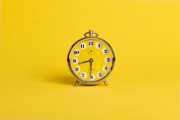 istock Round yellow alarm clock on a bright yellow background with space for copy 1941855857