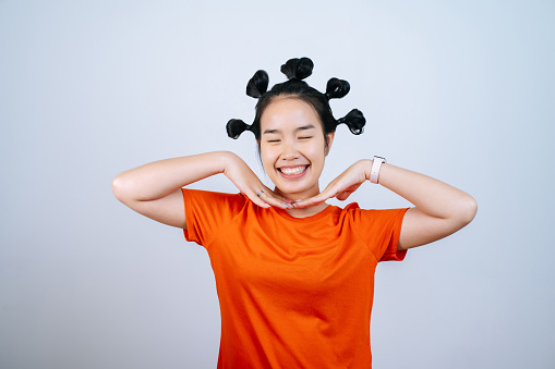 Portrait of Young Asian woman with many bun hair and smiling at camera on white background in studio,Hair styling