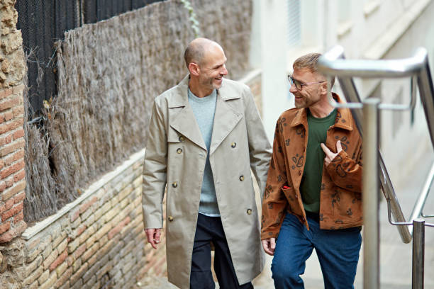 istock Mature male couple walking, talking, and smiling 1941880057