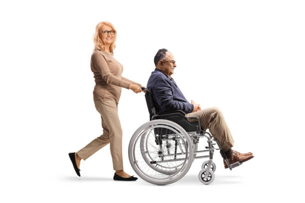 woman pushing a man in a wheelchair - physical injury men orthopedic equipment isolated on white imagens e fotografias de stock