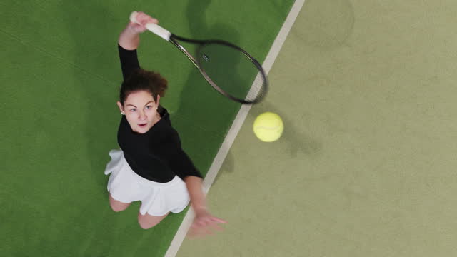 SLO MO SPEED RAMP Directly Above Shot of Active Young Female Tennis Player Serving Ball on Court in Sports Club