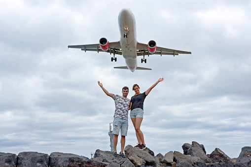 Commercial airplane on a happy couple with open arms