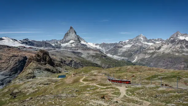 Swiss Alps in Summer with Gornergrat Bahn - Gornergrat Matterhorn Railway Train moving up the Mountain towards Riffelalp  - Gornergrat Mountain Top. Riffelberg, Zermatt, Switzerland, Europe.