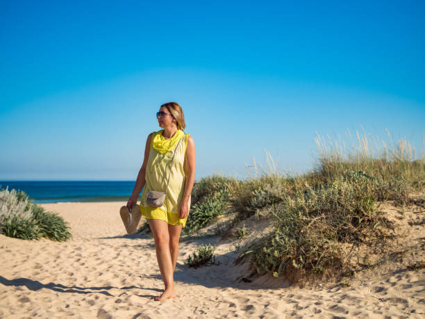istock Beautiful woman walking on beach 1941919460