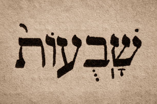 Single hebrew word Shavuot on page of old Torah book. English translation is Feast of Weeks. One of biblically-ordained Three Pilgrimage Festivals. Jewish holiday. Hebrew script. Closeup una sola palabra hebrea shavuot en la página del antiguo libro de la torá. la traducción al español es fiesta de las semanas. uno de los tres festivales de peregrinación ordenados bíblicamente. festividad judía. escritura hebrea. closeup.