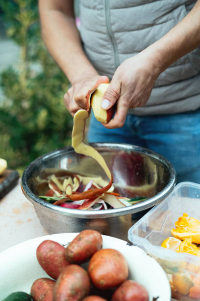 istock Close up of a man peeling vegetables and making compost from leftovers at an open kitchen outdoors at back yard. Sustainable lifestyle and zero waste cooking concept. 1941944976