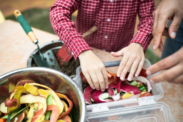 istock Family making compost from leftovers at an open kitchen outdoors at back yard. Father teaches his child to grow organic plants. Sustainable lifestyle and zero waste cooking concept. 1941948184