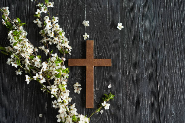 istock Cross with flowers on a wooden background 1941955711