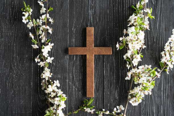 istock Cross with flowers on a wooden background 1941955712