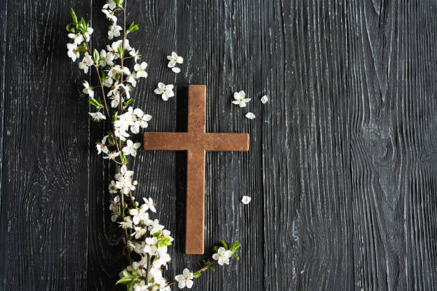 istock Cross with flowers on a wooden background 1941955714