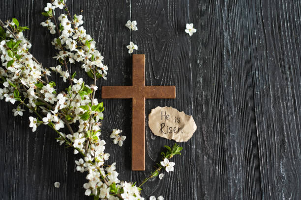 istock Cross with flowers on a wooden background 1941956717