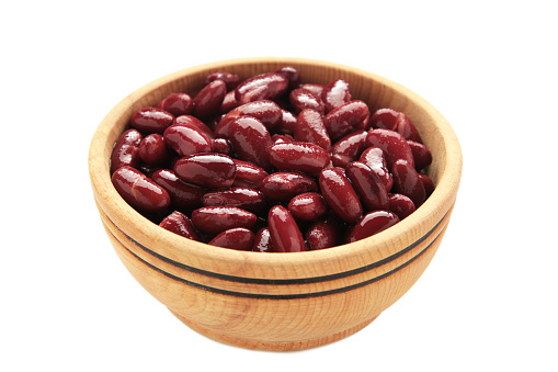Red beans in wooden bowl isolated on white background. Top view