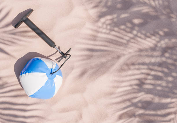 Smiling boy lying on the sand and posing with ball