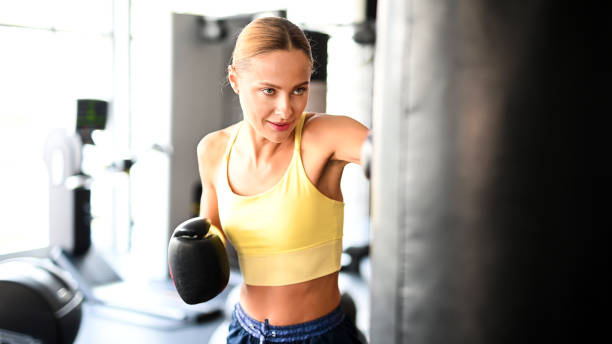 istock Beautiful young woman lifting dumbbells in a gym 1942004367