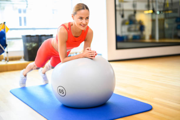 istock Beautiful athletic woman doing exercises with a gym ball 1942011925
