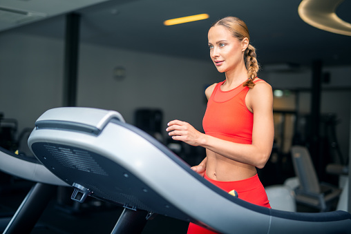 Woman running on a treadmill in a gym, cardio workout