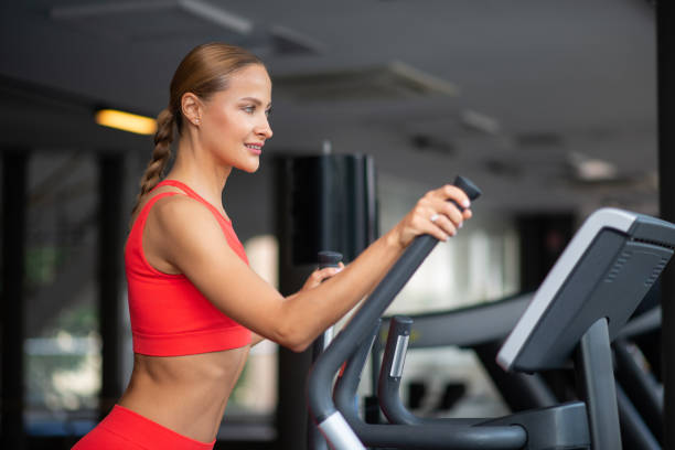istock Woman training on the elliptical machine 1942035154