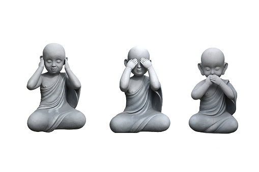A group of three small wise monk statues  isolated on white (see no evil, hear no evil, speak no evil)