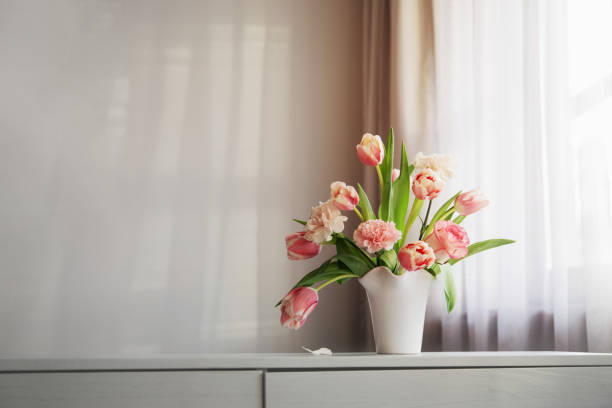 istock pink spring flowers in white ceramic vase in modern home interior 1942083252